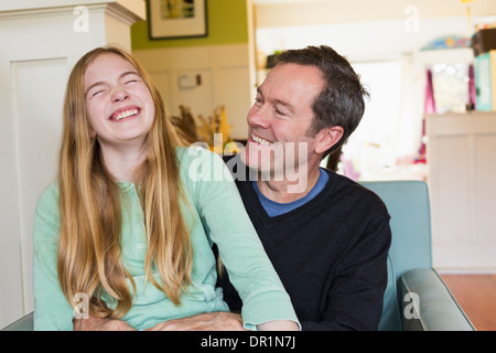 Caucasian father and daughter laughing in living room Stock Photo