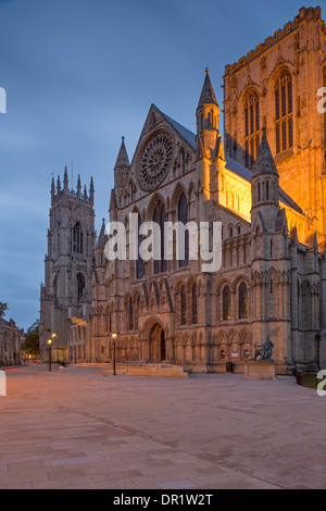 Evening in quiet, scenic piazza - south entrance & illuminated tower of magnificent Minster against dark sky - York, North Yorkshire, England, UK. Stock Photo