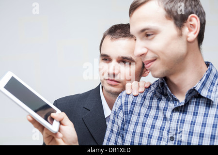 Two happy businessmen looking at digital tablet. Stock Photo