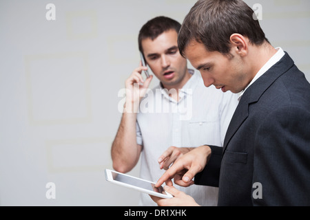 Two businessmen using digital tablet and smartphone. Stock Photo