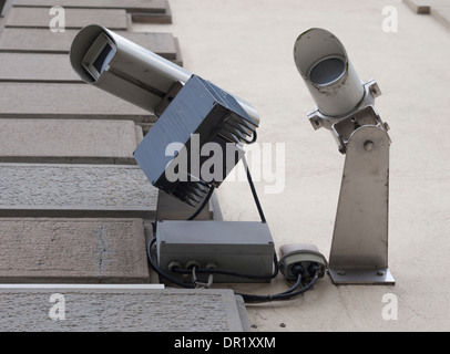 Two security cameras fixed to a building's exterior wall Stock Photo