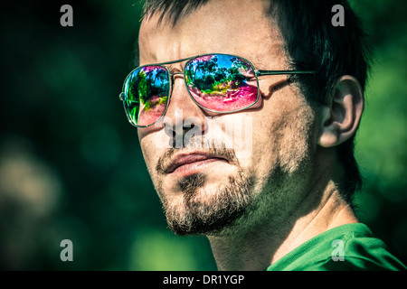 Portrait of young man wearing sunglasses with colorful reflection Stock Photo