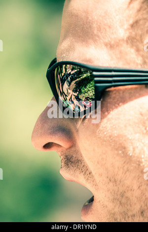 Detail of man face with open mouth wearing sport sunglasses Stock Photo