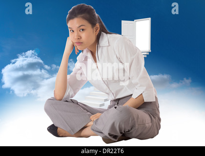 Composite image of businesswoman sitting cross legged Stock Photo