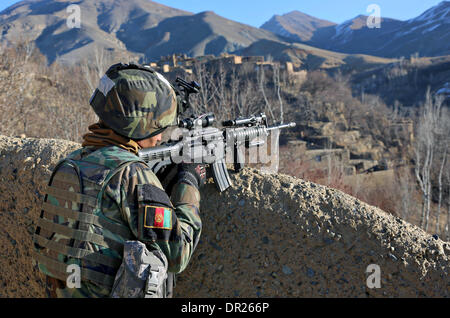 Afghan special operation force soldiers survey the valley for any suspicious activity during an operation to capture Taliban leaders January 15, 2014 in Ghorband district, Parwan province, Afghanistan. Stock Photo