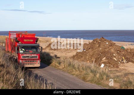 Norfolk, UK. 17th Jan, 2014. Debris washed up on Norfolk beaches from the December 2013 tidal surge being cleared at Hemsby and Scratby.  Among more than 5000 square feet of rubbish and ripped-up vegetation, remains of bungalows and holiday chalets destroyed during the highest tides in 60 years, including a fridge door, toilet seats and twisted metal from of an old bed. Credit:  Adrian Buck/Alamy Live News Stock Photo