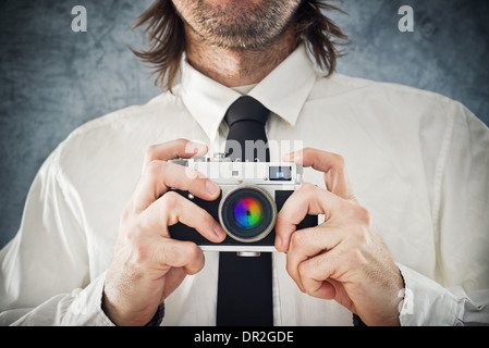 Businessman taking picture with retro style photo camera Stock Photo