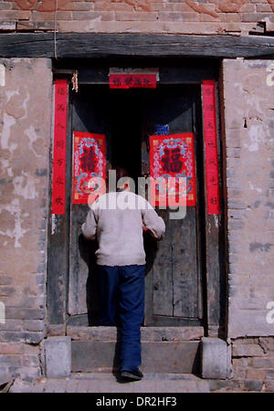 Zhengzhou. 18th Jan, 2014. Photo taken on April 12, 2012 shows a villager pushing the door of her home in Songxian County of central China's Henan Province. The Chinese Character 'fu', which means 'good luck', is common everywhere across China during the Spring Festival. It is popular for its propitious meaning, also can be interpreted as 'happiness', which the Chinese people believe will give them blessing in the coming new year. © Wang Song/Xinhua/Alamy Live News Stock Photo