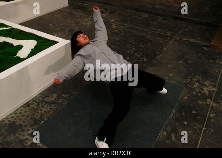 Beijing, China. 18th Jan, 2014. A woman performs in an installation art creation at the 798 Art Zone in Beijing, capital of China, Jan. 18, 2014. A Xu Zhen's art show was held here on Saturday. Xu Zhen is a Chinese contemporary artist, whose extensive body of work includes photography, installation art, video and performance art. Credit:  Ren Zhenglai/Xinhua/Alamy Live News Stock Photo