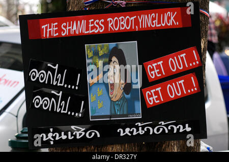 Bangkok, Thailand. Jan. 18th, 2014. a stinging satirical sign on Thai politics tied to a tree during the protests. After a deadly bomb attack on Friday in Bangkok, Tens of thousands of protesters took to the streets to demand the resignation of Thai Prime Minister Yingluck Shinawatra. 'Shutdown Bangkok' is organized by the People's Democratic Reform Committee (PDRC). Credit:  Kraig Lieb / Alamy Live News Stock Photo