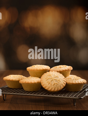 Homemade traditional mince pies on cooling rack with snowflake decoration Stock Photo