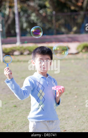Boy blowing bubbles Stock Photo
