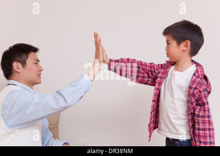 Father and son giving each other high five Stock Photo