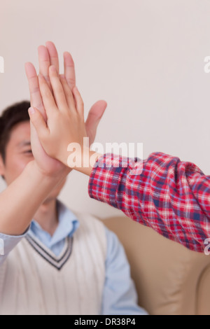 Father and son giving each other high five Stock Photo