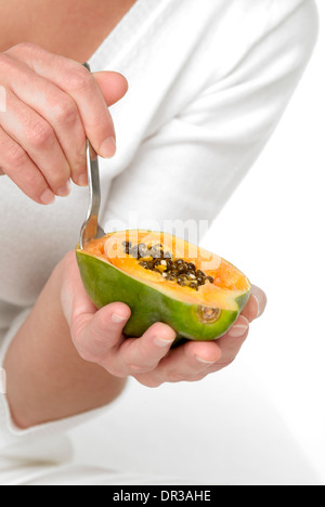 Woman eating a papaya Stock Photo