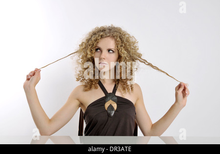 Young woman sitting bored on a desk Stock Photo