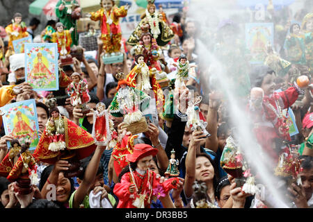 Manila, Philippines. 19th Jan, 2014. A Filipino man raises his Santo