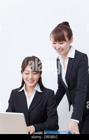 Two young business women using laptop Stock Photo