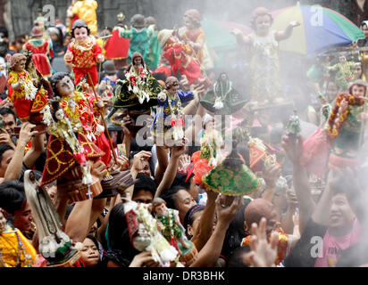 Manila, Philippines. 19th Jan, 2014. A Filipino man raises his Santo