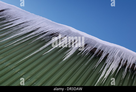 Huge icicles hang down from roof Stock Photo