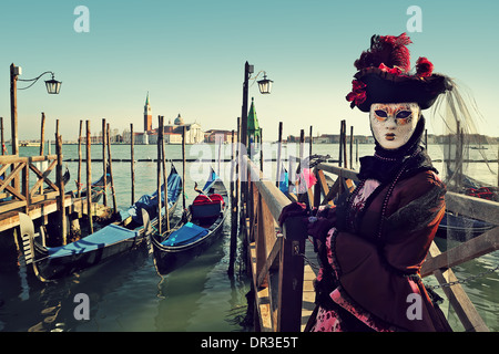 Unidentified participant in mask and costume on background of Grand canal and San Giorgio Maggiore in Venice. Stock Photo