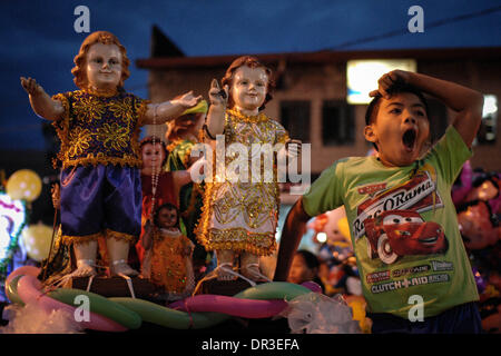 Manila, Philippines. 19th Jan, 2014. A Filipino boy yawns next to Santo Nino statues during the Feast of Santo Nino at a church in the poor district of Tondo. The festival is celebrated every third Sunday of January which honors the Child Jesus more commonly known as ''Santo Nino'' to Filipino Catholics. Credit:  Ezra Acayan/NurPhoto/ZUMAPRESS.com/Alamy Live News Stock Photo