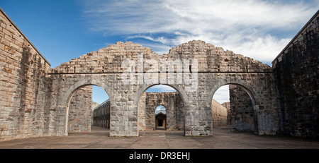 Ruins of Trial Bay Gaol near South West Rocks, NSW Australia showing high brick walls and arched entrance ways against blue sky Stock Photo