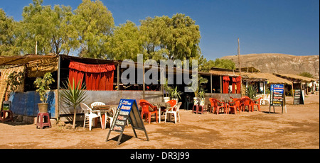 Open air restaurant with red plastic tables and chairs outside corrugated iron shelter / shack in city of Ayacucho in Peru Stock Photo