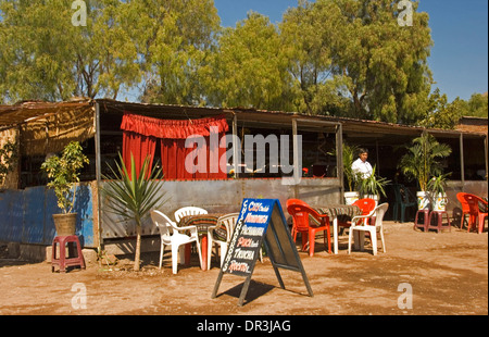 Open air restaurant with plastic tables and chairs outside corrugated iron shelter / shack in city of Ayacucho in Peru Stock Photo