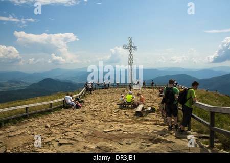 Tourists on Tarnica peak with metal cross, Bieszczady Mountains Poland Stock Photo