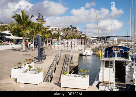 Seafront promenade around the marina in coastal holiday resort of Puerto Calero, Lanzarote, Canary Islands, Spain Stock Photo