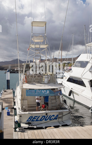 Tourists' charter fishing boat equipped with rods moored in the marina in Puerto Calero, Lanzarote, Canary Islands, Spain Stock Photo