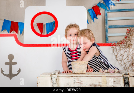 Two little girls play with seashells, sea theme. Stock Photo