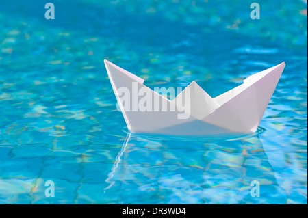 White paper boat floating in the water Stock Photo