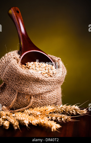 Wheat in small burlap sack and wooden spoon  Stock Photo