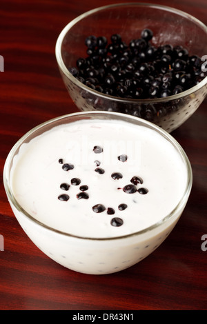 Home-made yogurt with bilberries in glass bowl closeup Stock Photo