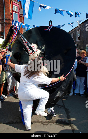 a local girl dancing with the ' red oss ' on obby oss day in padstow, cornwall, uk Stock Photo
