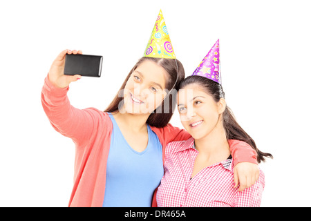 Two teenage girls taking pictures of themselves with cell phone Stock Photo