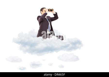 Young businessman looking through binoculars seated on cloud Stock Photo