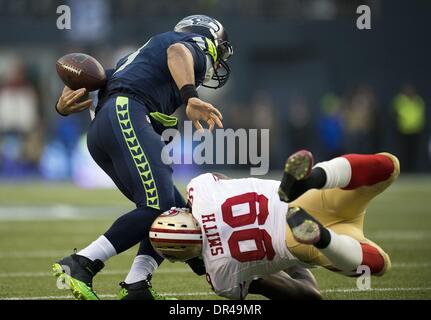 Seattle, WA, USA - San Francisco 49ers outside linebacker Aldon Smith (99) knocks the ball loose from Seattle Seahawks quarterback Russell Wilson (3) and recovered by the 49ers in the first quarter of the NFC Championship game at CenturyLink Field in Seattle on Sunday, Jan. 19th Jan, 2014. 19, 2014 Credit:  Action Plus Sports/Alamy Live News Stock Photo