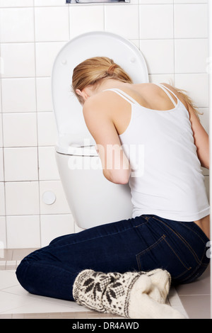Young caucasian woman is vomiting in the bathroom. Bulimia, sick concept. Stock Photo