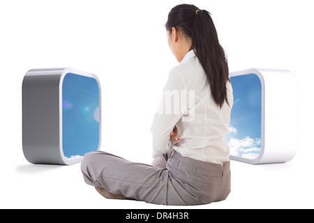 Composite image of businesswoman sitting cross legged Stock Photo