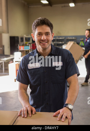 Worker smiling in warehouse Stock Photo