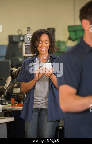 Worker using cell phone in warehouse Stock Photo