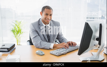 Smiling businessman using computer at office Stock Photo