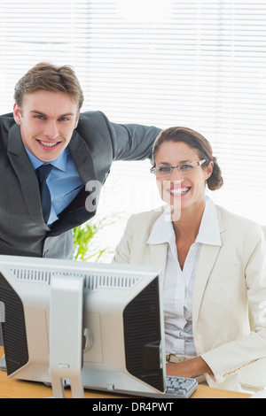 Confident smiling business couple with computer Stock Photo