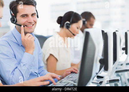 Business colleagues with headsets using computers Stock Photo