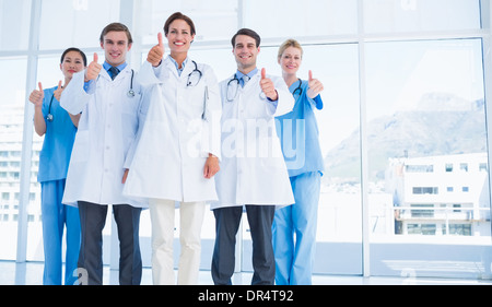 Doctors gesturing thumbs up at hospital Stock Photo