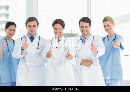 Doctors gesturing thumbs up at hospital Stock Photo
