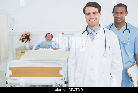 Two smiling doctors with patient in hospital Stock Photo